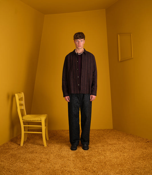 Model wearing the black wine line Cullu Overshirt with black trousers