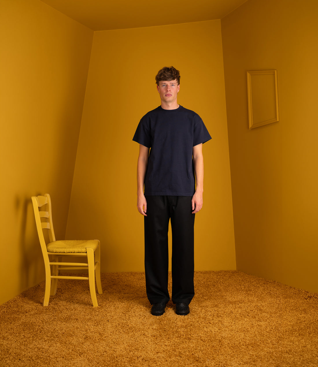 Model wearing the navy Atelier Neighbourhood Wonder T with black trousers