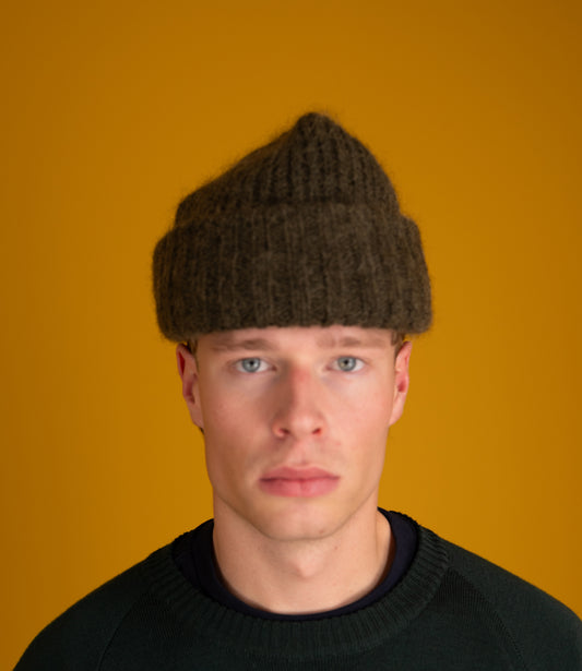 Model wearing the sage Orlu Beanie with a black sweater