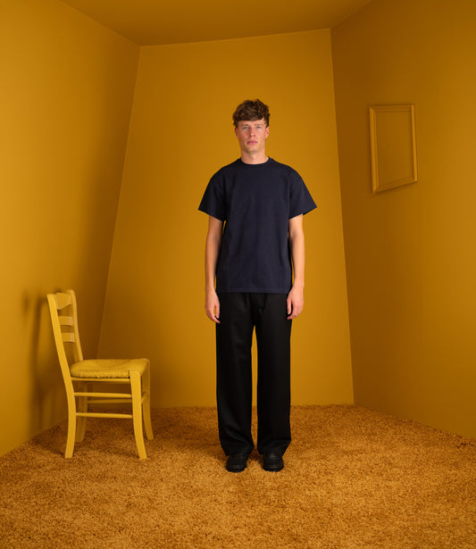 Model wearing the navy Atelier Neighbourhood Wonder T with black trousers