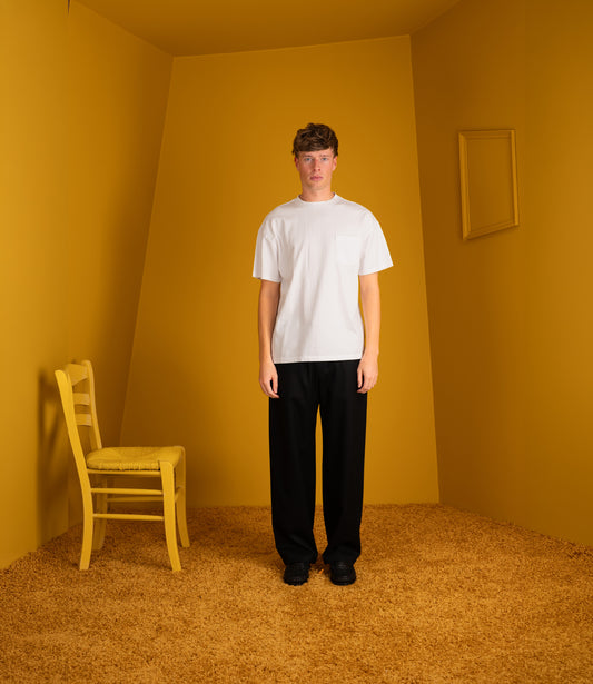 Model wearing the white Atelier Neighbourhood Wonder T with black trousers