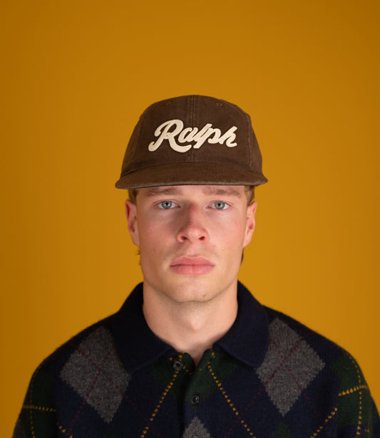 Model wearing the brown Polo Ralph Lauren Ralph script cap, close-up portrait